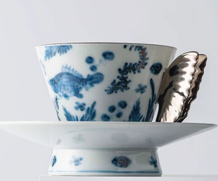 Blue and white porcelain butterfly coffee cup side profile on white background