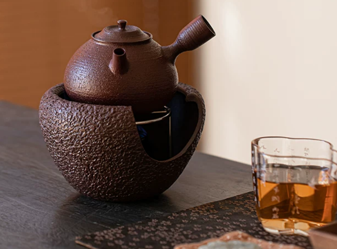 Pouring hot water from coarse pottery kettle
