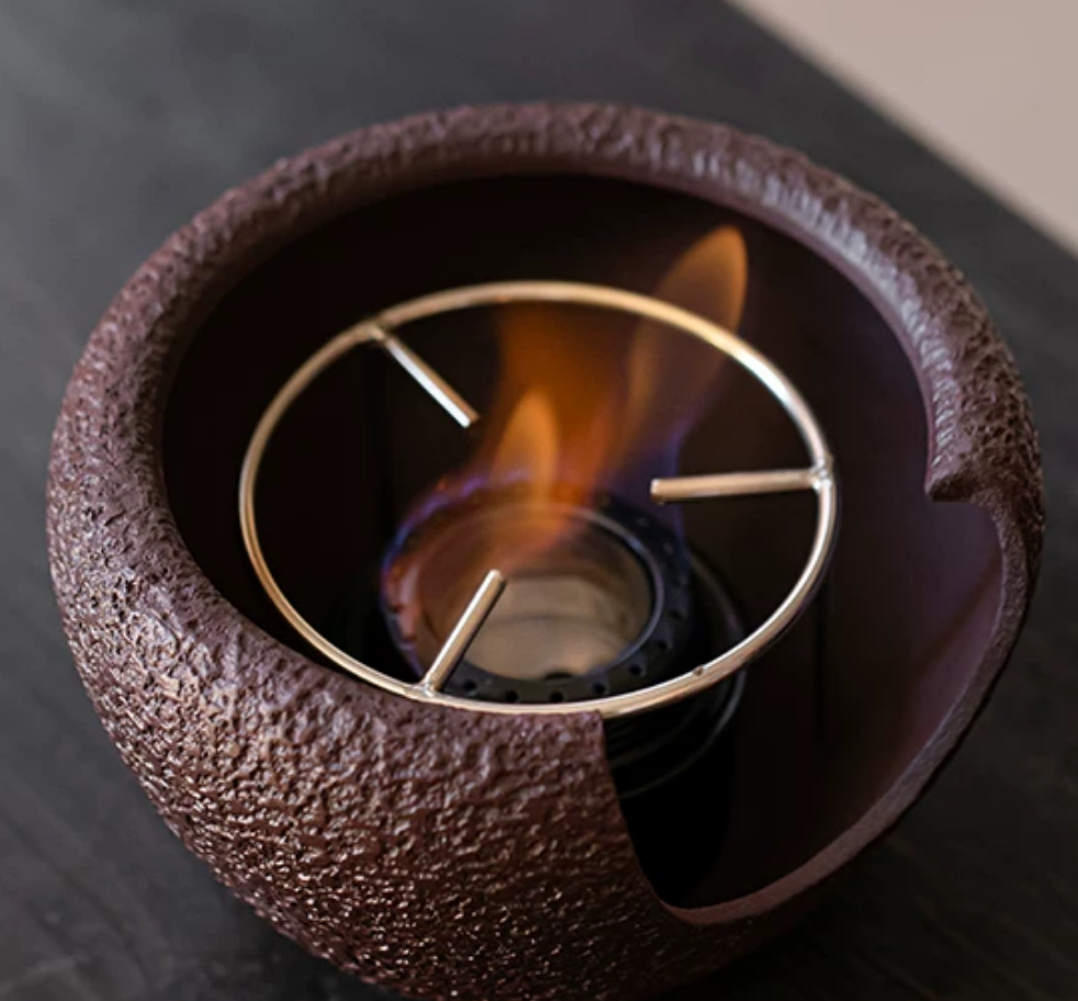 Close-up of coarse pottery kettle held in hands